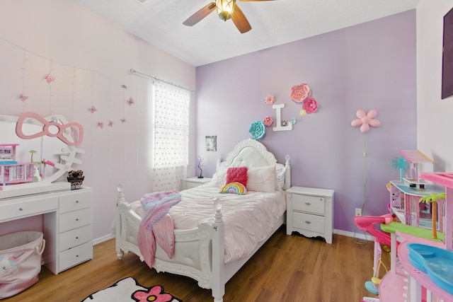 bedroom featuring baseboards, a ceiling fan, and wood finished floors