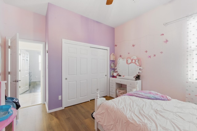 bedroom with a ceiling fan, wood finished floors, a closet, and baseboards