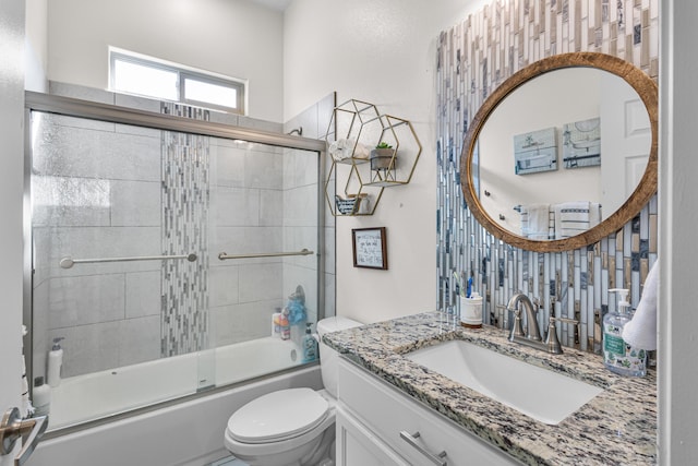 full bathroom with bath / shower combo with glass door, vanity, and toilet