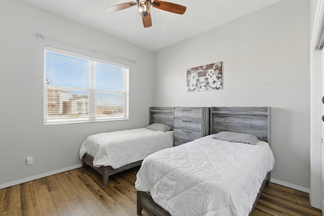 bedroom featuring a ceiling fan, baseboards, and wood finished floors