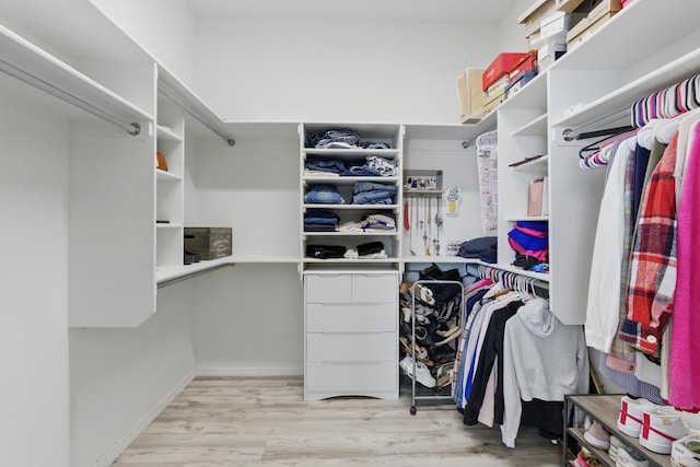 walk in closet with wood finished floors