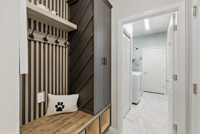 mudroom with baseboards, marble finish floor, and washer and clothes dryer