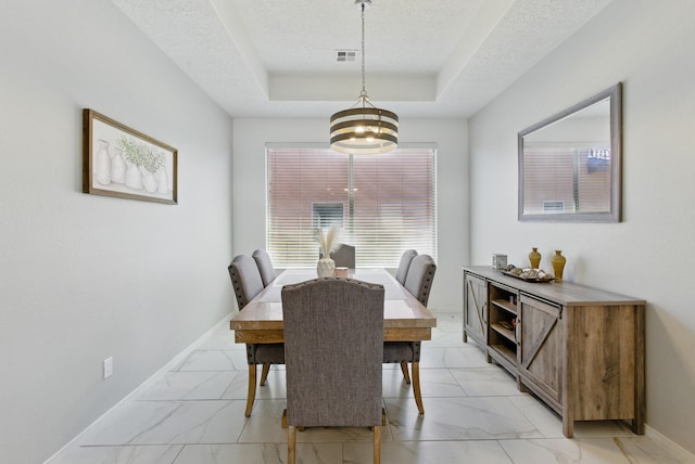 dining area with visible vents, baseboards, a raised ceiling, and marble finish floor