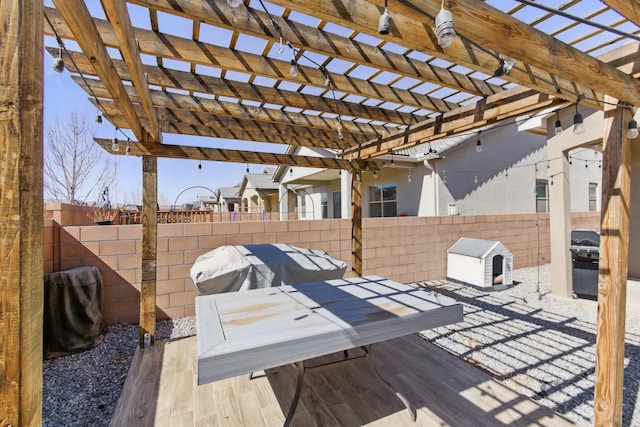 wooden deck featuring a grill, a fenced backyard, and a pergola