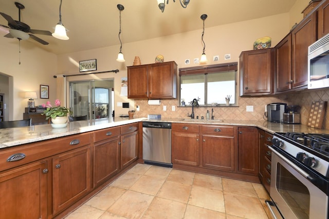 kitchen with sink, decorative light fixtures, ceiling fan, stainless steel appliances, and decorative backsplash