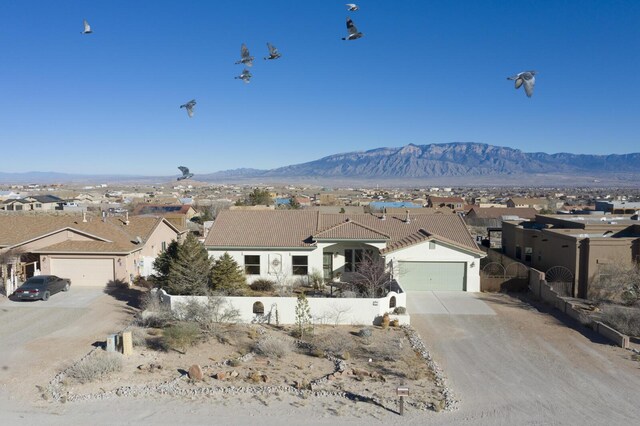 ranch-style home featuring a garage and a mountain view