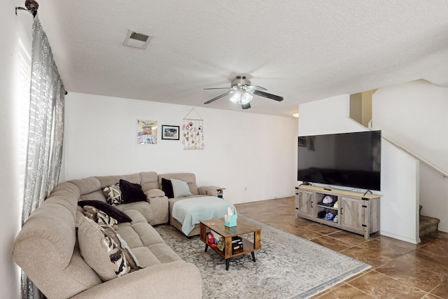 living room featuring ceiling fan and a textured ceiling