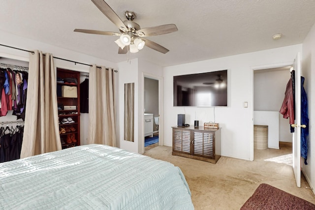 bedroom featuring ensuite bath, ceiling fan, a textured ceiling, light carpet, and a closet