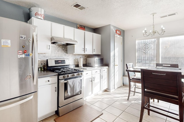 kitchen with decorative light fixtures, white cabinets, decorative backsplash, stainless steel appliances, and an inviting chandelier