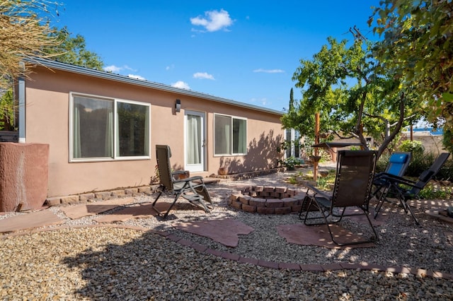 back of property featuring a patio area and an outdoor fire pit