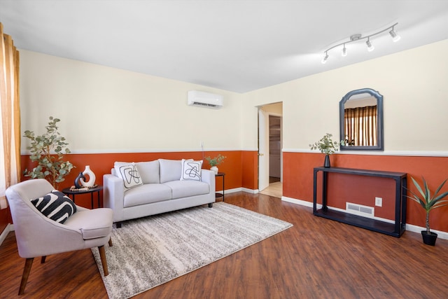 living room featuring hardwood / wood-style flooring and an AC wall unit