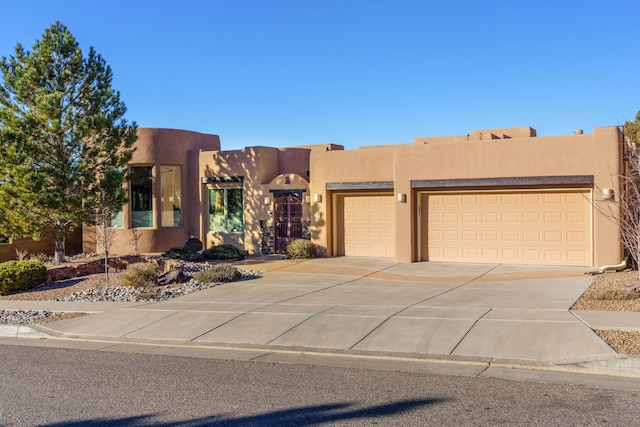 pueblo-style house featuring a garage