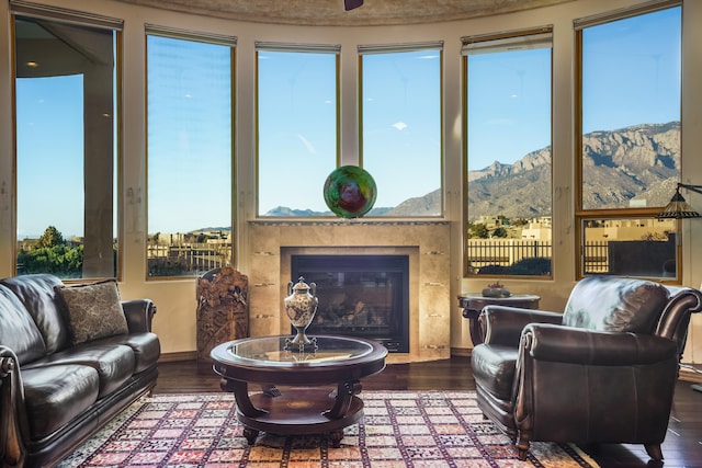 living room with a high end fireplace, a mountain view, and hardwood / wood-style floors