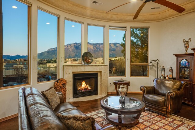 bedroom with dark wood-type flooring, a raised ceiling, and ceiling fan