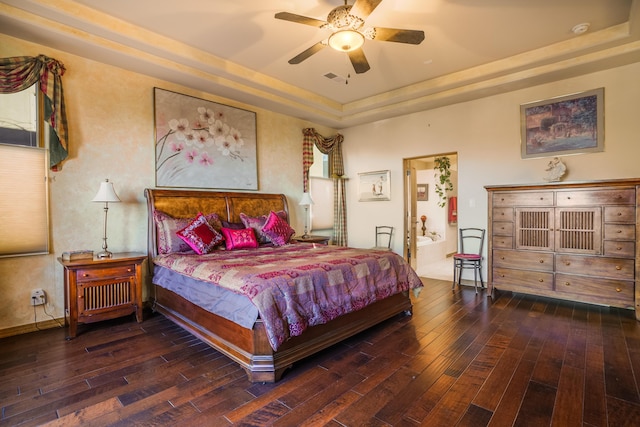 bedroom with dark wood-type flooring, a raised ceiling, and ceiling fan