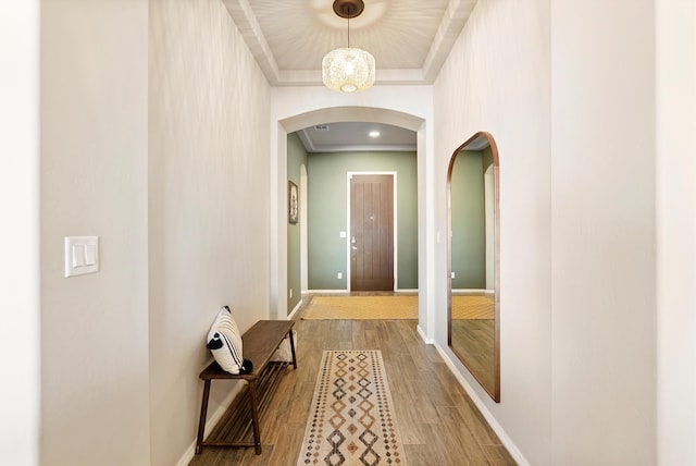 corridor with ornamental molding and light hardwood / wood-style flooring