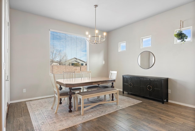 dining area with plenty of natural light, an inviting chandelier, and dark hardwood / wood-style flooring