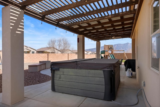 view of patio featuring a mountain view, a hot tub, a pergola, and a playground