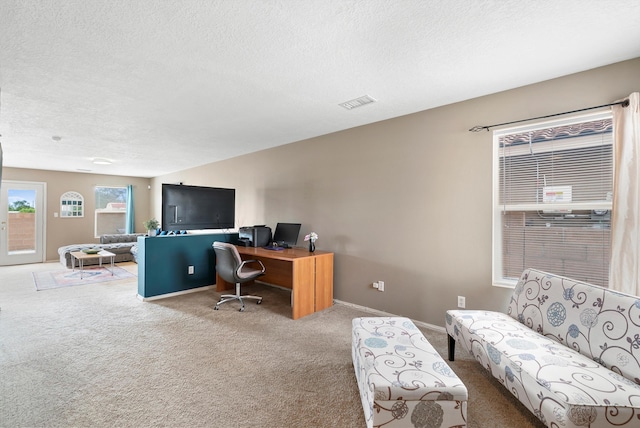 carpeted home office with a textured ceiling