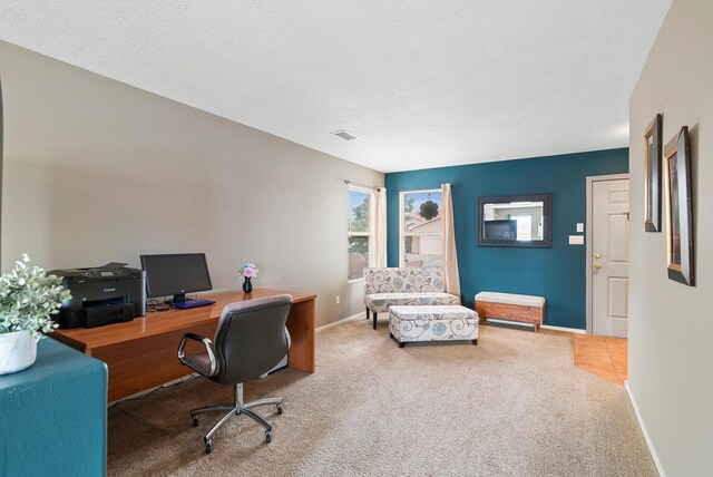 home office featuring light colored carpet and a textured ceiling