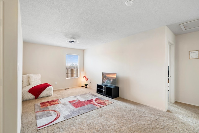 interior space featuring light colored carpet and a textured ceiling