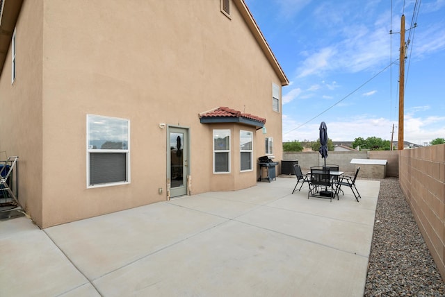 back of house with central AC unit and a patio