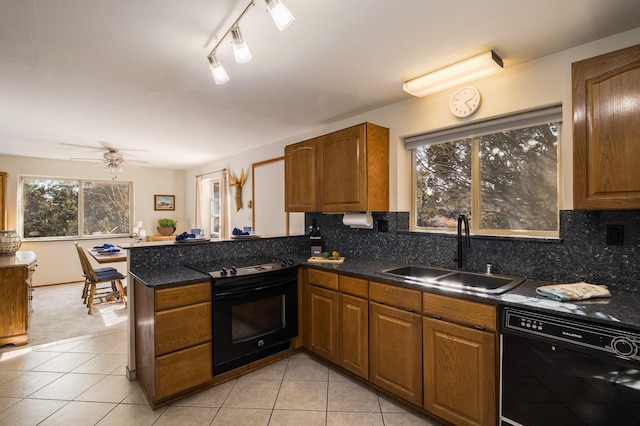 kitchen featuring sink, decorative backsplash, black appliances, and kitchen peninsula