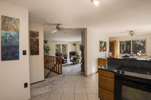 kitchen featuring black / electric stove, light colored carpet, and ceiling fan