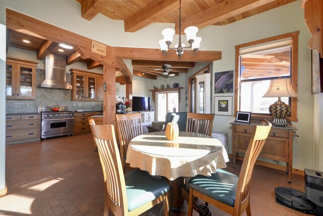 dining space featuring beam ceiling, ceiling fan with notable chandelier, wooden ceiling, and a healthy amount of sunlight