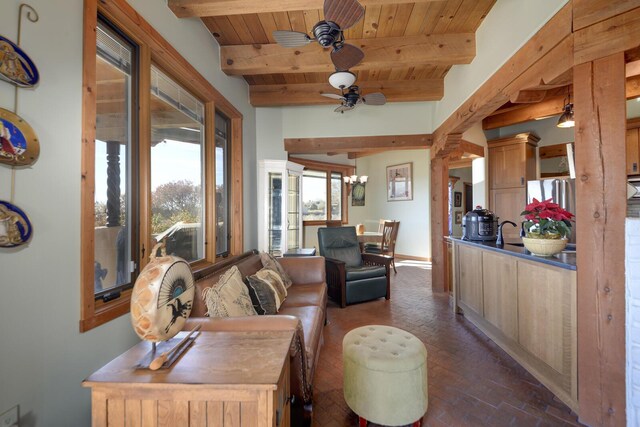 living room with ceiling fan with notable chandelier, wood ceiling, and beam ceiling