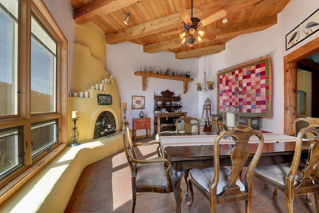 dining room with beamed ceiling, ceiling fan, and wood ceiling