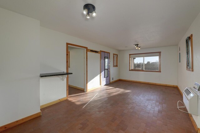 unfurnished room featuring a wall unit AC