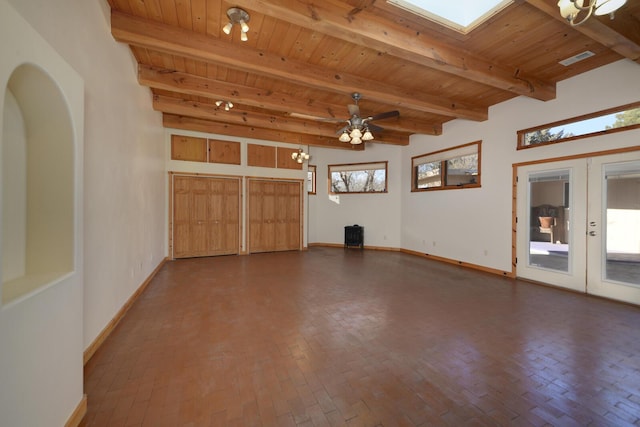 426 Ruffles Ln, Corrales, NM 87048 - unfurnished living room featuring wooden ceiling with exposed beams, healthy amount of natural light, baseboards, french doors, and brick flooring