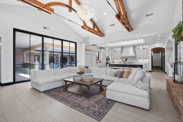 living room with an inviting chandelier, high vaulted ceiling, and beamed ceiling