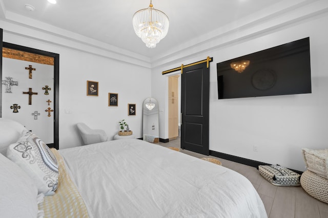 bedroom with a barn door and a chandelier