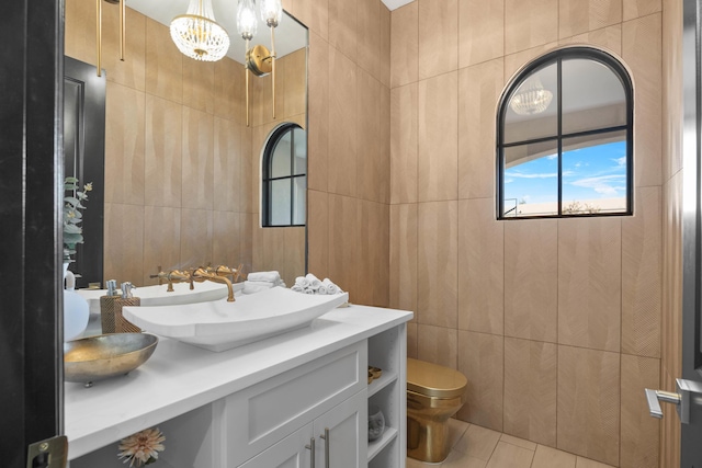 bathroom featuring vanity, toilet, tile patterned flooring, and tile walls