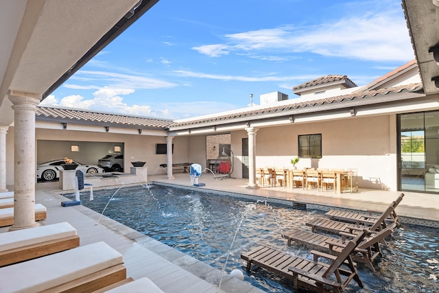 view of swimming pool with pool water feature and a patio area