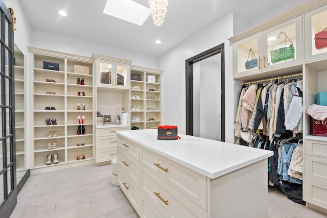 walk in closet featuring light hardwood / wood-style flooring and a skylight