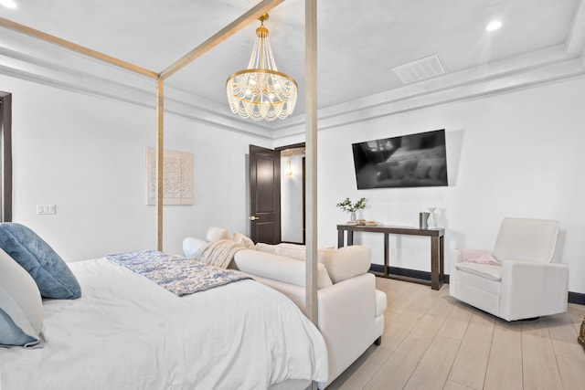 bedroom with a notable chandelier and light hardwood / wood-style flooring