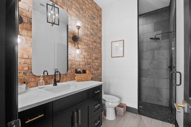 bathroom featuring vanity, toilet, and a shower with shower door