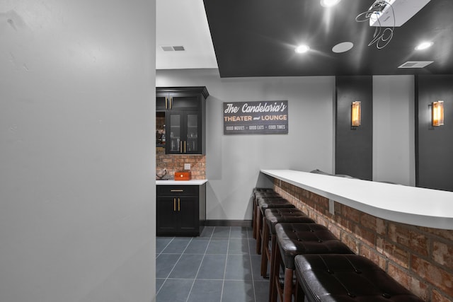 bar featuring dark tile patterned floors and backsplash