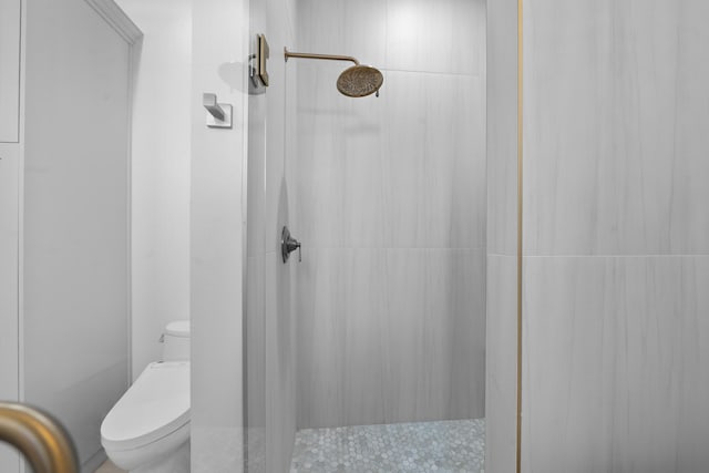 bathroom with tiled shower and toilet