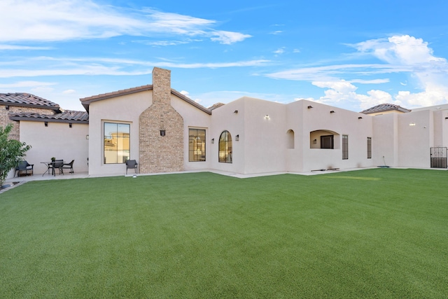 back of house with a patio and a lawn