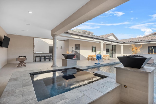 view of patio featuring a fire pit and an outdoor bar