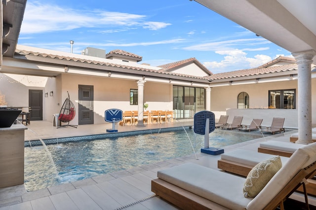 view of swimming pool with pool water feature and a patio