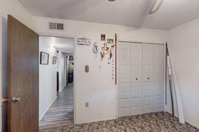 unfurnished bedroom with ceiling fan, a closet, and a textured ceiling