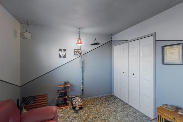 sitting room with carpet and a textured ceiling