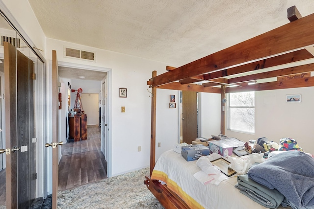 carpeted bedroom featuring beamed ceiling and a textured ceiling