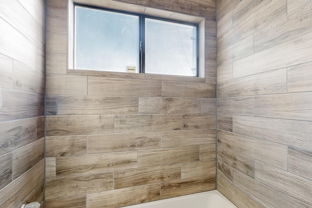 bathroom featuring a tile shower and a wealth of natural light