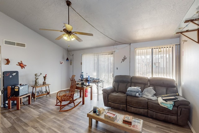 living room featuring ceiling fan, lofted ceiling, and wood-type flooring